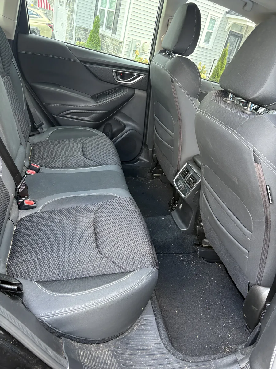Rear-seat car interior with dirt and debris before detailing